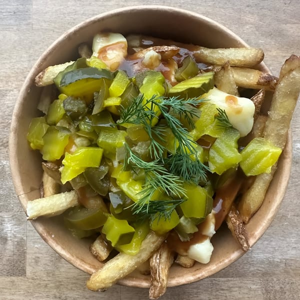 The Flying V's poutine with fries, cheese curds, gravy, chopped pickles, and fresh dill.